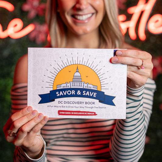 Young woman holding a DC Discovery Book in Washington DC, ready to explore top places to visit and things to do in DC. (1x1 Square Image)