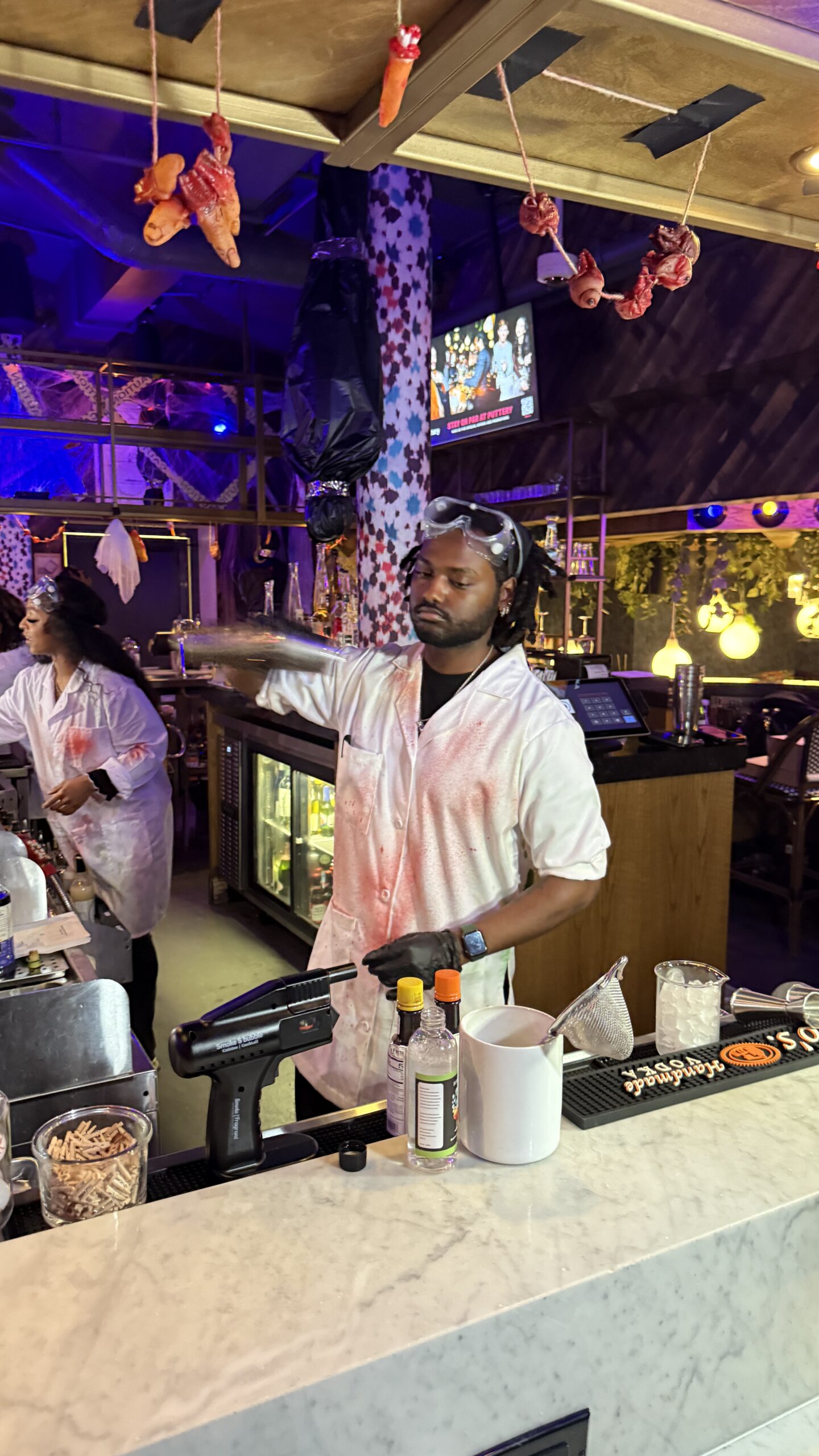 Bartender in a laboratory coat preparing a cocktail at Frankenstein's Mad Scientist Cocktail Lab