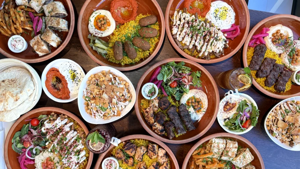 AYAT DC lunch special platters on a table in Foggy Bottom: kefta, chicken kebab, shawarma and falafel platters with hummus, muhammara, labneh and rice