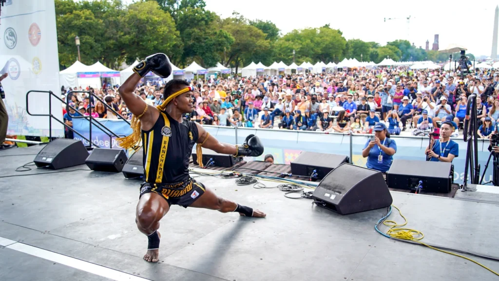 Muay Thai champion Buakaw Banchamek performing a kick on the Sawasdee DC stage in front of a large crowd on the National Mall in 2025