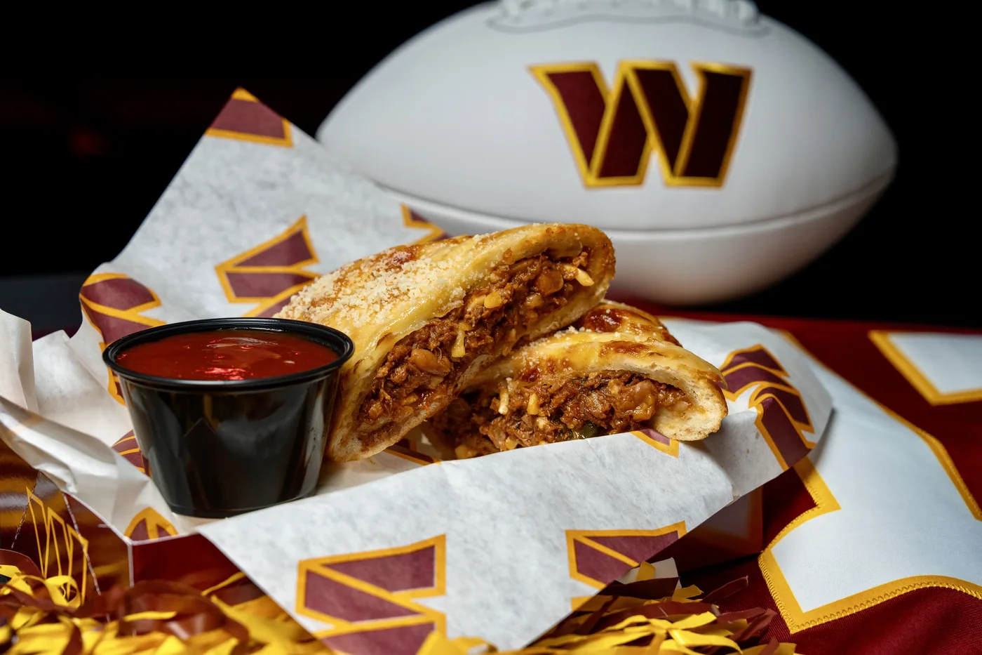 DC BBQ Pocket cut open to show its meat and cheese filling, served with dipping sauce