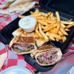 Cut shawarma wrap with fries and sauce at Mashahweez Shawarma & Grill in Vienna