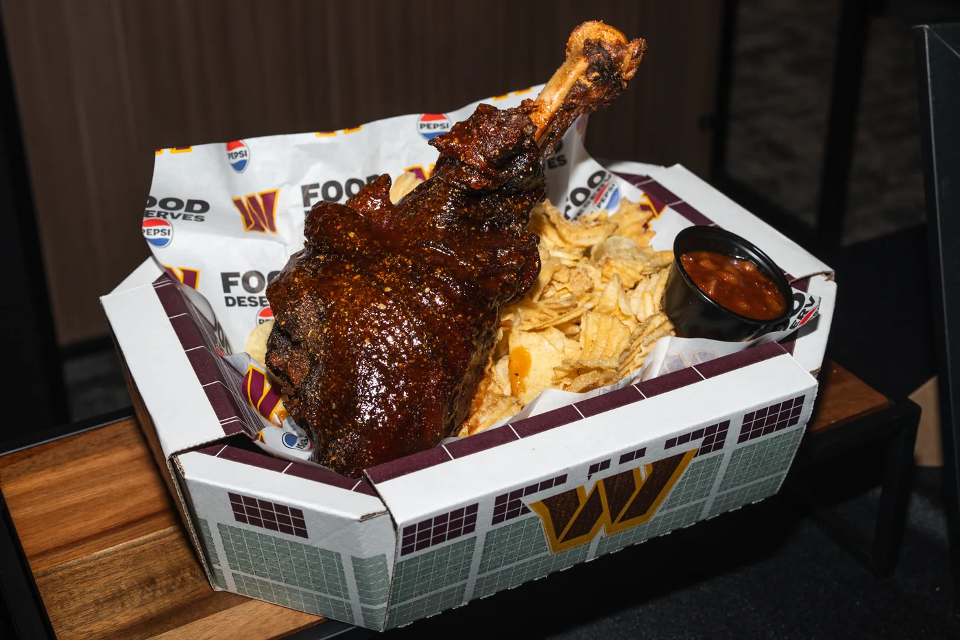 Smoked turkey leg served with chips and baked beans in a Commanders tray