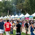 Crowds walking past rows of white Thai food vendor tents at the 2025 Sawasdee DC Thai Festival on the National Mall in Washington DC