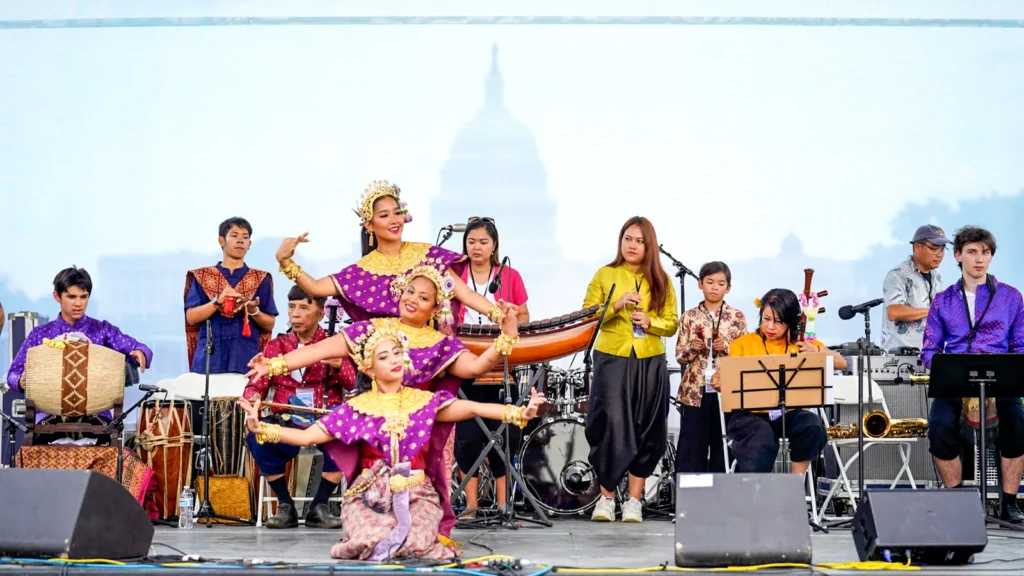 Thai musicians and dancers in traditional dress performing on the Sawasdee DC stage with the U.S. Capitol dome in the background