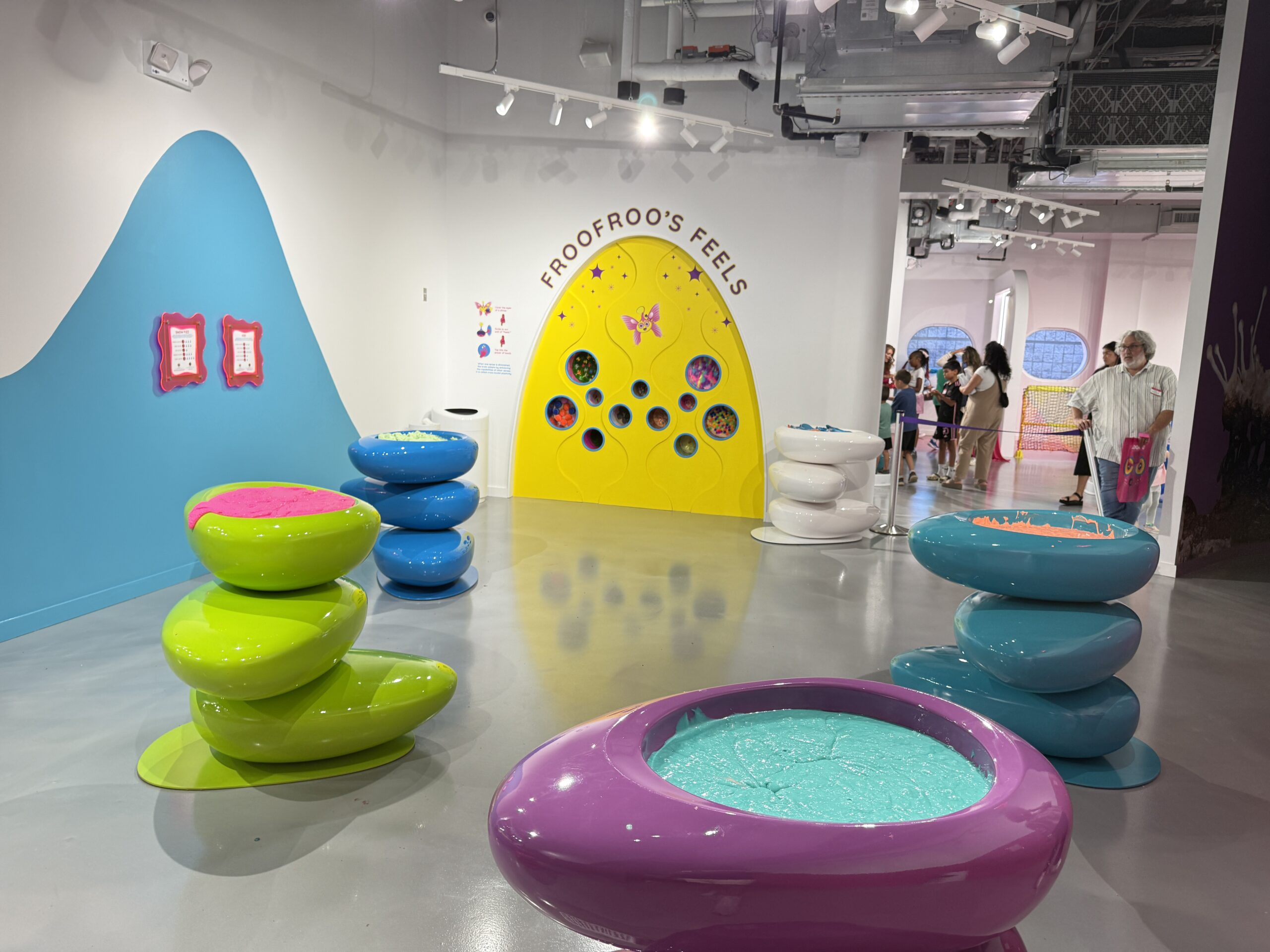 Brightly colored slime bowls beside the yellow Froofroo’s Feels wall
