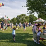Families at an outdoor Northern Virginia park event with kites, tents and kids playing on the grass
