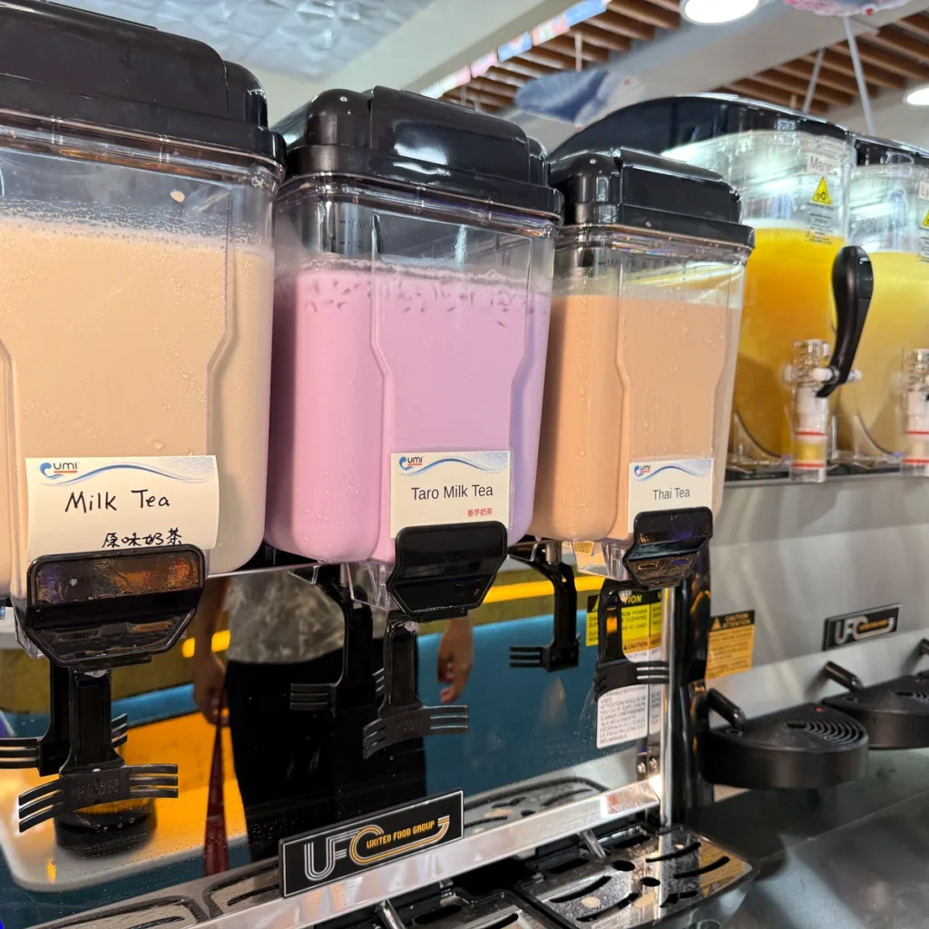 Milk tea, taro milk tea and Thai tea dispensers next to the slushie machines at UMI Alexandria, all included with dine-in