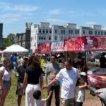 Crowds browsing rows of Asian food stalls on a sunny day at a previous Asia in a Bite festival