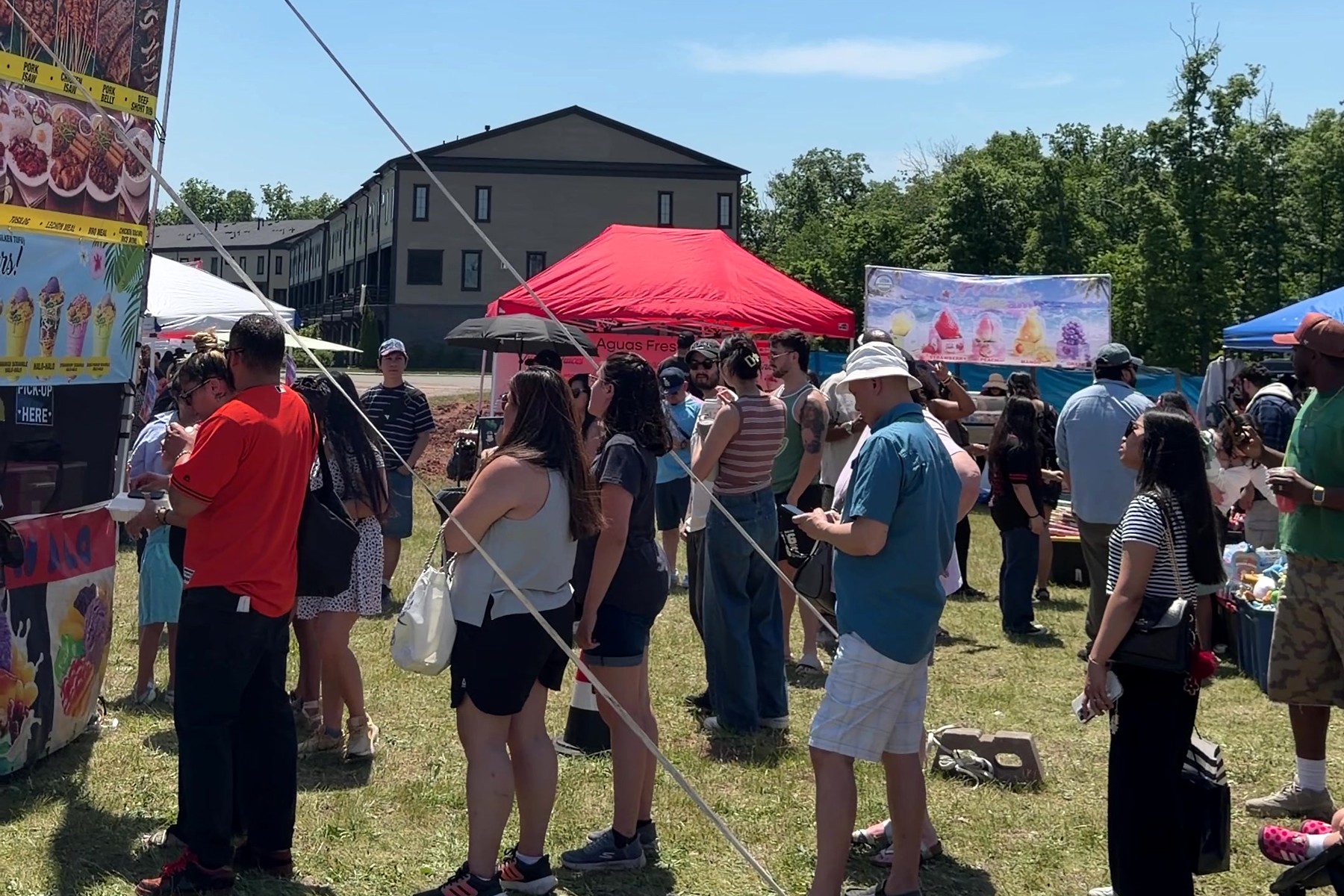 A crowd gathered between food stalls and market tents at a previous Asia in a Bite festival