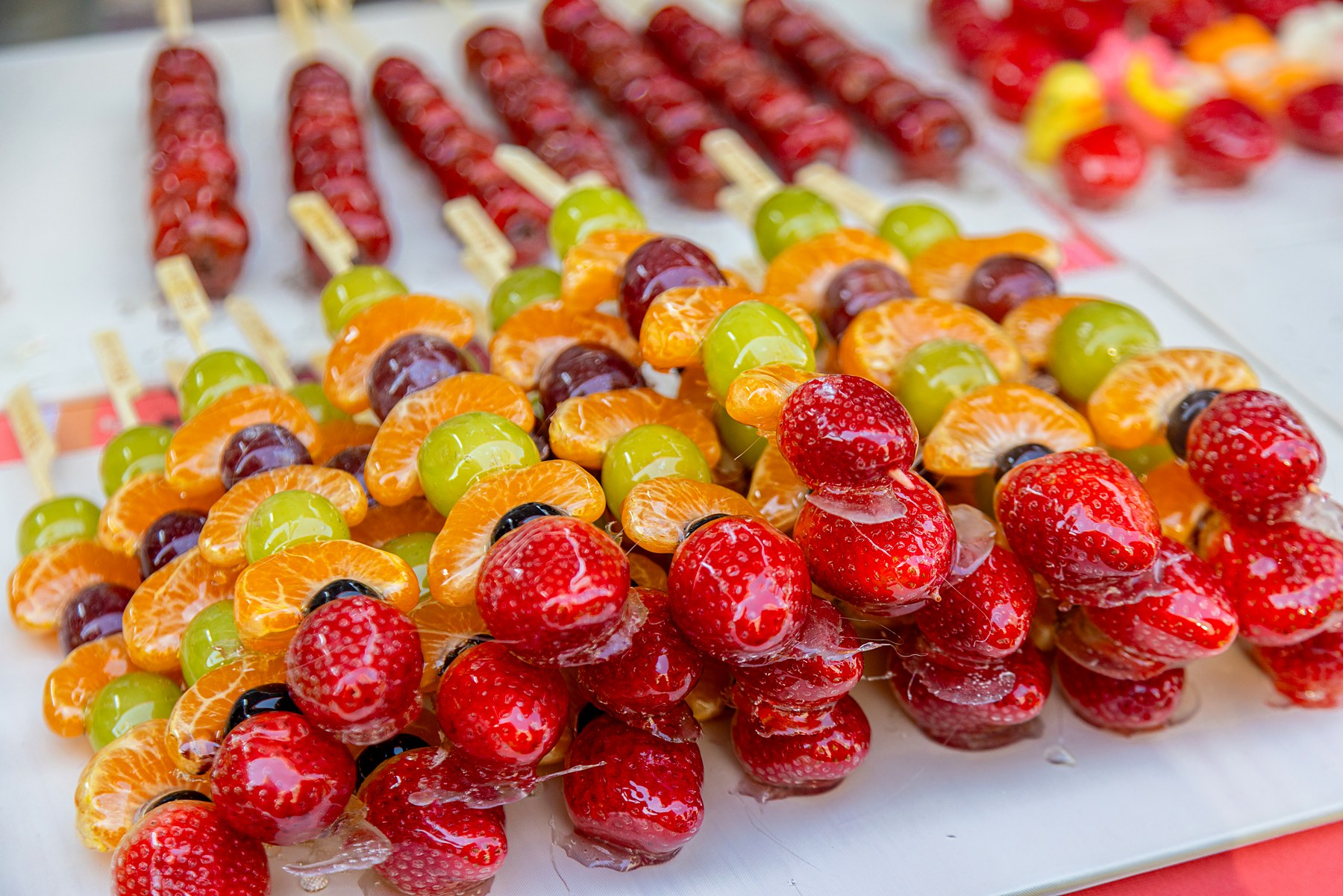 Glossy fruit skewers arranged in rows at a previous Asia in a Bite food festival