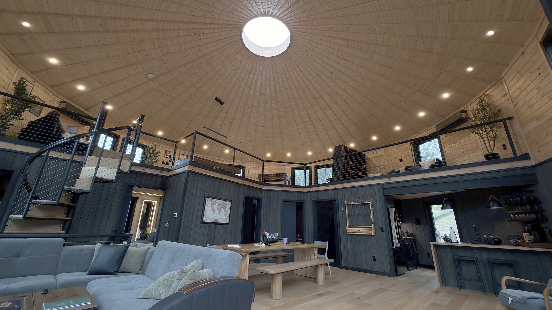 Circular skylight, loft, kitchen, and seating in Luray Yurt’s great room