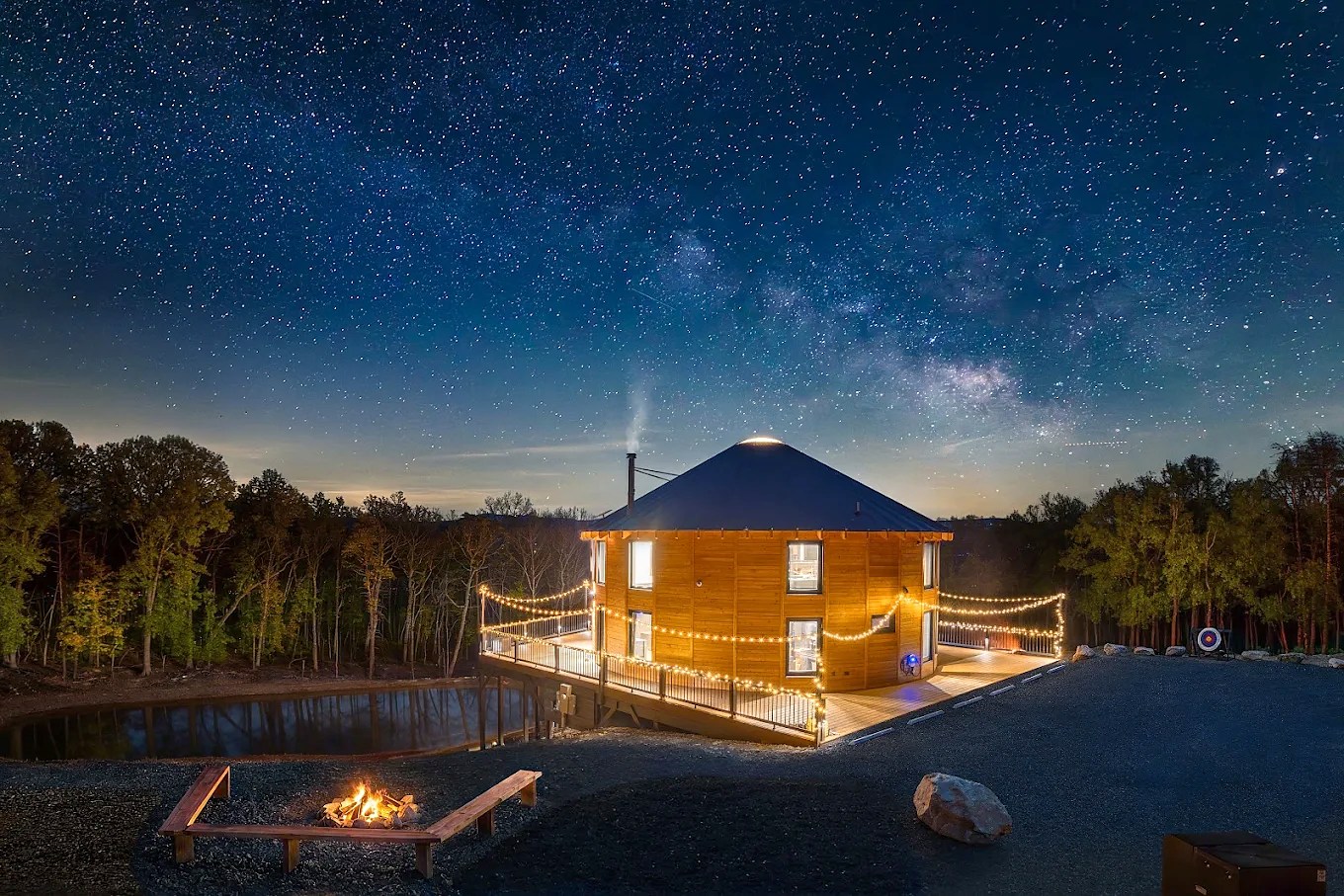 Luray Yurt at night with a star-filled sky, glowing deck lights, and a fire pit