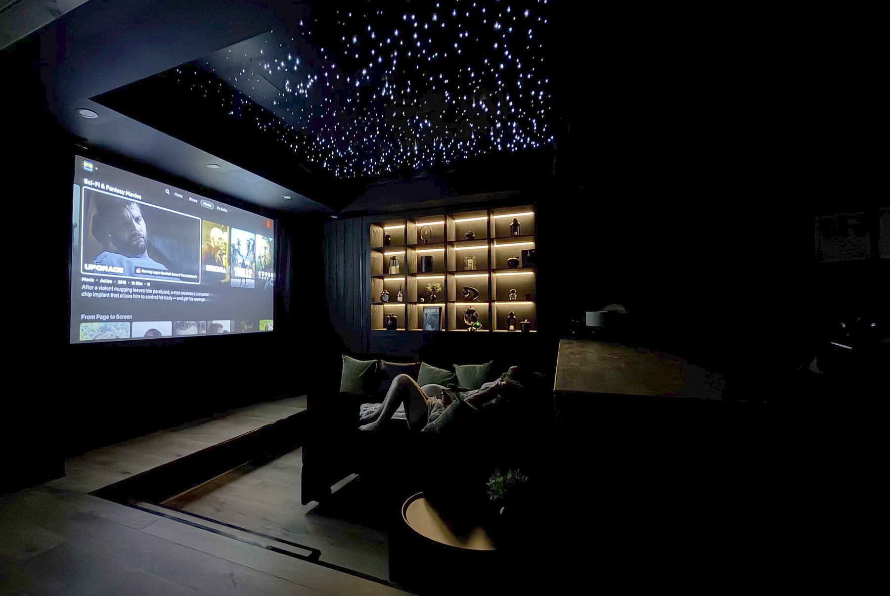Projection screen, star ceiling, and couch seating in Luray Yurt’s theater