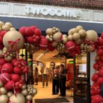 Twosome Place sign above the red and gold balloon arch at its Old Town Alexandria entrance