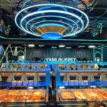 Inside Yami Buffet in Alexandria: a long buffet line under a blue neon ring light, with a lit Yami Buffet sign on the back wall
