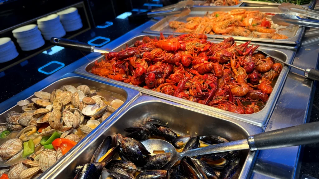 Steam trays of crawfish, mussels and shrimp on the seafood station at Yami Buffet